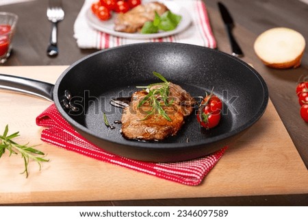 Pork neck steak in a teflon pan Royalty-Free Stock Photo #2346097589