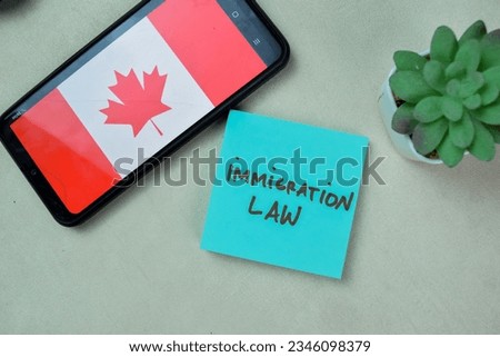 Concept of Immigration Law write on sticky notes isolated on Wooden Table.