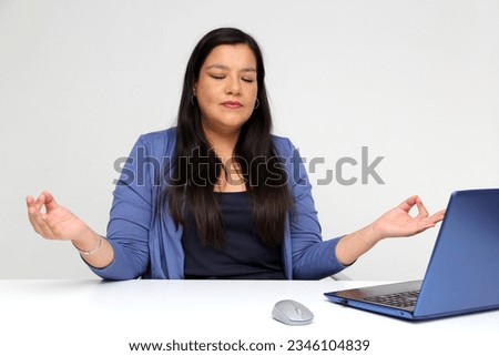 40-year-old Latina woman breathes pranayama and practices yoga in her office to relax and de-stress from work pressure and prevent burnout Royalty-Free Stock Photo #2346104839