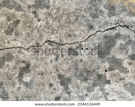 a photography of a crack in the concrete with a fire hydrant, concrete surface with cracks and cracks in it.