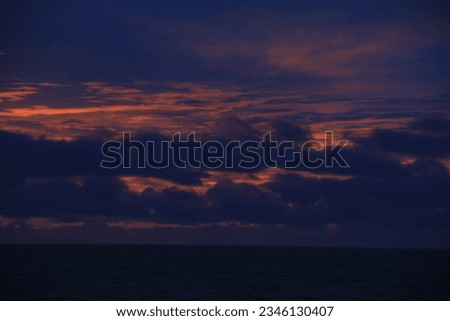 A journey at sea aboard a large ship reveals a stunning sunset view.