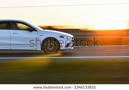 Fast car on the highway in the sunset. Royalty-Free Stock Photo #2346133833