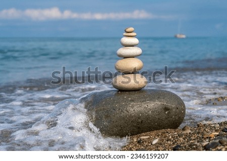 Pyramid of stones for meditation lying on sea coast at sunset