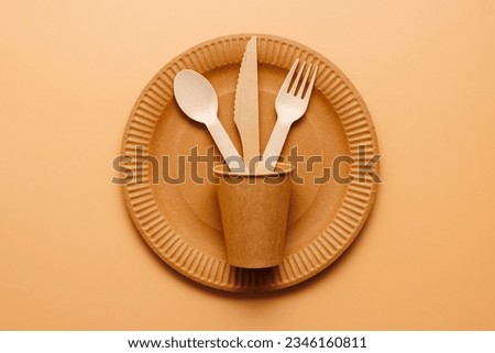 A set of disposable tableware on a brown background Royalty-Free Stock Photo #2346160811