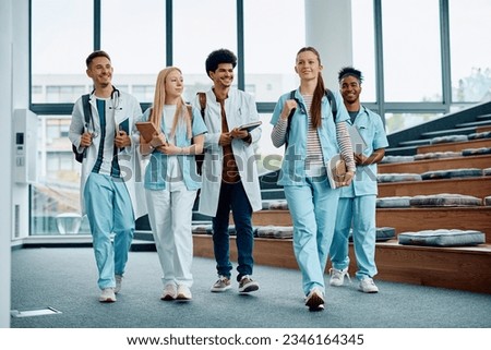 Group of medical and nursing students leaving the amphitheater after a lecture at medical university.  Royalty-Free Stock Photo #2346164345