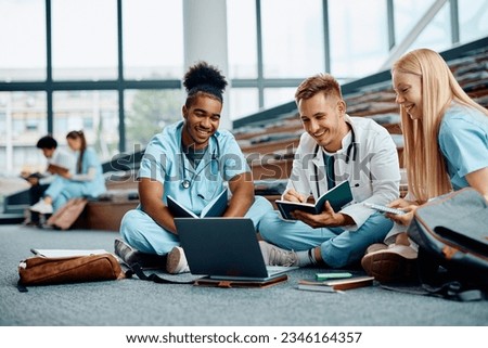 Group of happy medical students using laptop while learning in lecture hall. Royalty-Free Stock Photo #2346164357