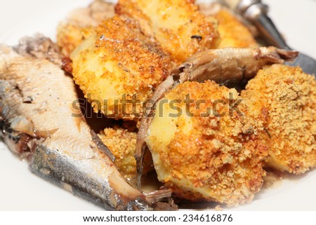 slices of smoked sprats canning and roasted potatoes