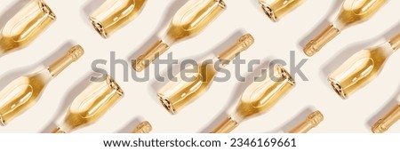 Minimal pattern of bottles of white sparkling wine, glass bright champagne bottle on beige as monochrome wide banner. Summer alcohol drinks background, happy holidays wallpaper, top view still life Royalty-Free Stock Photo #2346169661