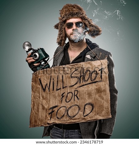 Photographer dressed as a homeless man, holding a sign " Will shoot for Food". Symbolises how hard it can be for photographers to make a decent living.