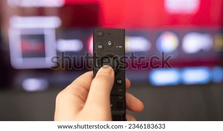 Tv online. Television streaming video. Media TV on demand. Online Multimedia video concept on TV set. Watching online TV with modern remote control in hand.