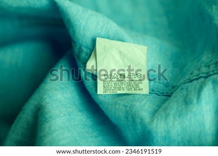 Clothing label on light green garment, top view