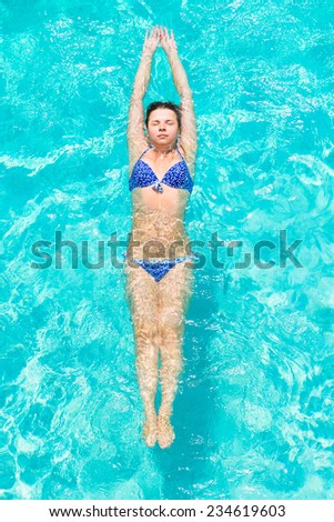 girl practicing swimming in the pool outdoors