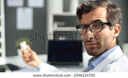 physician holds out his hand with jar of pills