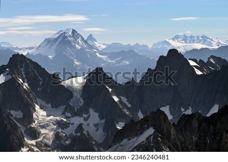 Mountain peaks in Mont Blanc massif, and in the background Grand Combin, Matterhorn (or Cervin) and Monte Rosa (Mont Rose) in Switzerland and Italian alps seen from Aiguille du Midi in summer Royalty-Free Stock Photo #2346240481