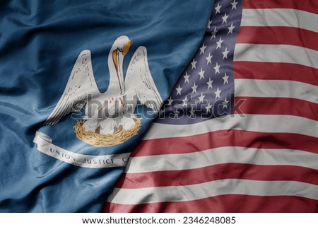 big waving colorful national flag of united states of america and flag of louisiana state . macro