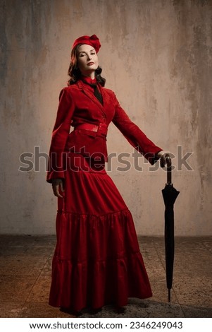 Mary Poppins. A stylish lady in a red old-fashioned suit with a hat and a lace umbrella Royalty-Free Stock Photo #2346249043