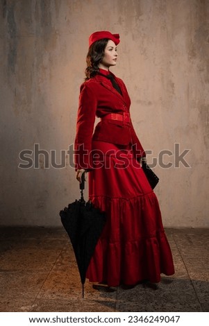 Mary Poppins. A stylish lady in a red old-fashioned suit with a hat and a lace umbrella Royalty-Free Stock Photo #2346249047