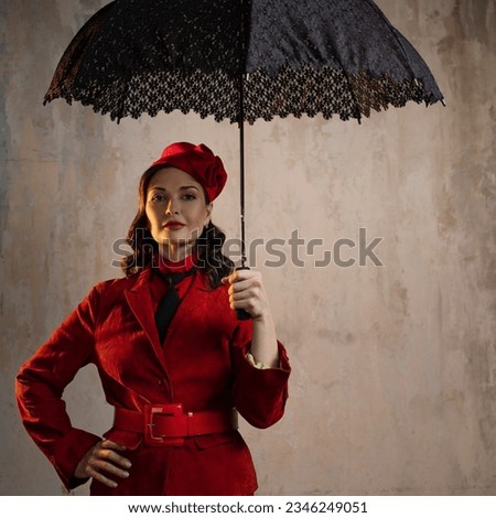 A stylish lady in a red old-fashioned suit with a hat and a lace umbrella Royalty-Free Stock Photo #2346249051