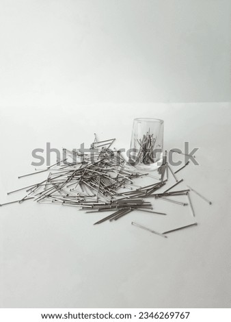 close-up of a bunch of scattered needles or pins or nail pins for hijab isolated on white background. Steel nails 