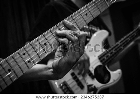 Close-up of man's hands playing bass guitar. Person playing bass guitar. Guitar strings. Person playing rock. Musical instrument Royalty-Free Stock Photo #2346275337
