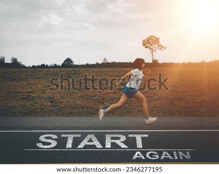 Start again.  Young Asian woman running forward in the evening. on the road with a message start again Trying to fight again not giving up Royalty-Free Stock Photo #2346277195