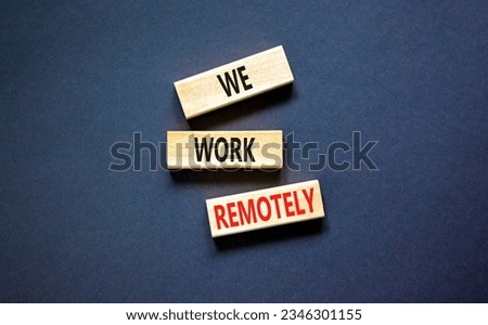We work remotely symbol. Concept words We work remotely on wooden block. Beautiful black table black background. Business we work remotely concept. Copy space.