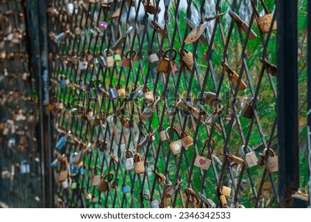 A mesh fence on the seashore with padlocks symbolizing love. Love locks are hung on the fence in large numbers on the sea promenade. Sea on background.