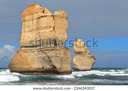 Westward view at low tide from the beach at the foot of the Gibson Steps of Gog -larger- and Magog -smaller- sea stacks eroded from the Port Campbell Limestone unit. Port Campbell NP-VIC-Australia. Royalty-Free Stock Photo #2346343037