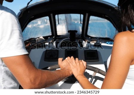 Photo of a couples hands while sailing boat on vacation.