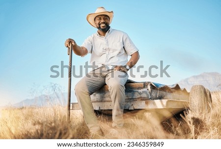 Happy, African farmer and portrait in the countryside and man, sitting and watching over environment, field and land. Farming, meadow and agriculture worker outdoor with smile or happiness in summer Royalty-Free Stock Photo #2346359849