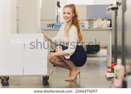 Young woman working in printing factory. Printing Press