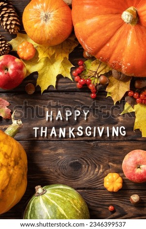 Autumn Day Thanksgiving background. Festive autumn decor from ripe pumpkins, berries and leaves on a wooden background. View from above. 