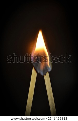 two match sticks sticking to one another and inflame Royalty-Free Stock Photo #2346426813
