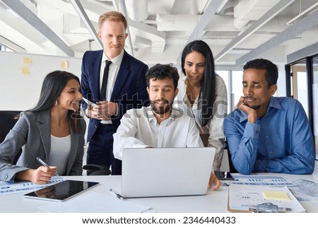 Busy diverse professional business people executives looking at laptop in office. International workers group and team leader having teamwork discussion managing project at work in meeting room. Royalty-Free Stock Photo #2346440433
