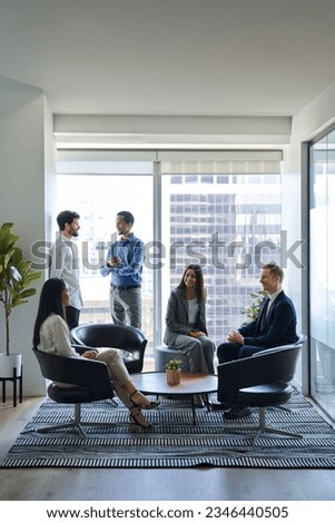 Busy diverse professional team business people workers talking in modern corporate office lobby. International coworkers group having teamwork conversation together at work meeting. Vertical shot Royalty-Free Stock Photo #2346440505