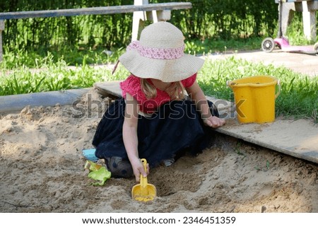 Little girl playing in sand at playground