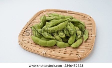 Raw edamame on a bamboo basket.Edamame are green soybeans. Royalty-Free Stock Photo #2346452323