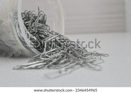 Closeup of paper clips on a light surface, ideal for office and stationery concepts and perfect for organizing and protecting documents. Royalty-Free Stock Photo #2346454965