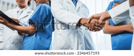 Group of medical staff doctor nurse and healthcare specialist profession handshaking in hospital. Medical teamwork and healthcare cooperation in panoramic banner background. Neoteric Royalty-Free Stock Photo #2346457193