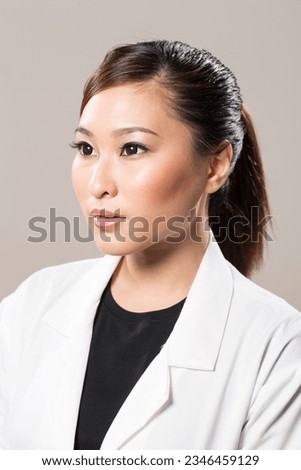 Beautiful Chinese lady doctor wearing a white lab coat. Royalty-Free Stock Photo #2346459129
