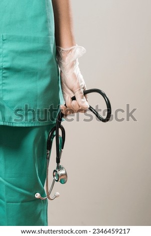 Close up view of a medical practitioner hand wearing latex gloves holding a stethoscope Royalty-Free Stock Photo #2346459217