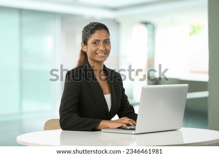 Portrait of a happy Indian business woman using on laptop. Royalty-Free Stock Photo #2346461981