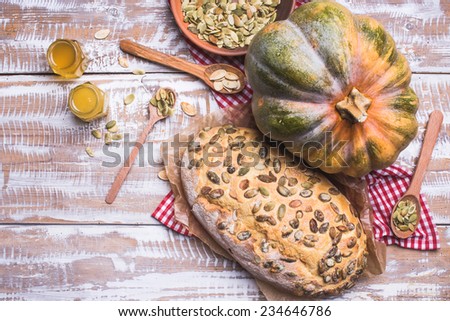 Newly baked bread with seeds and pumpkin on wooden table. Rustic style food photo