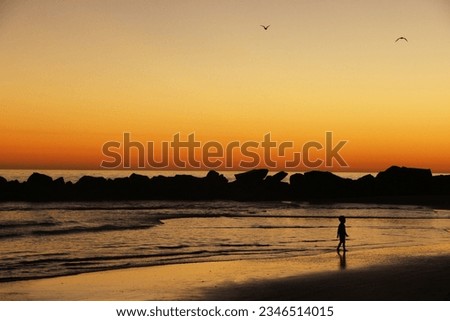 Panorama of calm waves with little child and golden dawn view at the background