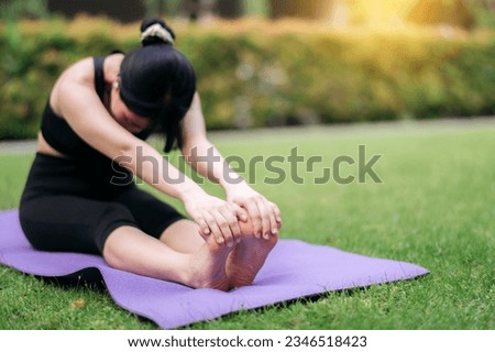 portrait fit young Asian woman in pink sportswear with yoga mat. stretching muscles in park. Achieve inner harmony through yoga. finds healing in nature, promoting well-being and good lifestyle. Royalty-Free Stock Photo #2346518423