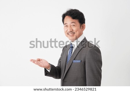Asian middle aged businessman pointing side in white background