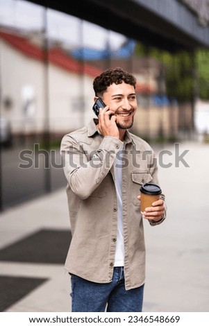 happy young man talk on phone and walk on street