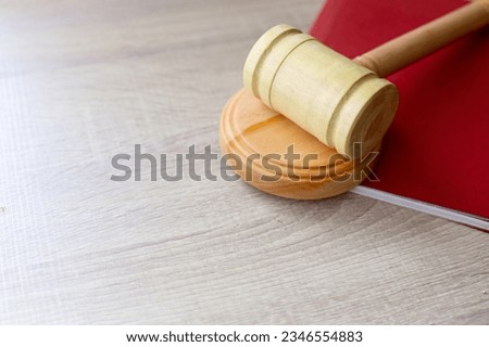 Judge gavel and red book on wooden table with copy space. Law firm concept