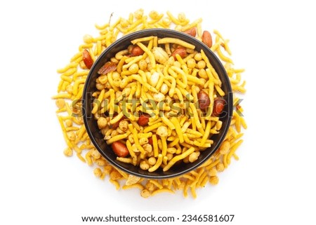 Close-up of South Mix Indian namkeen (snacks) on a ceramic black bowl. Isolated on white background. Top view