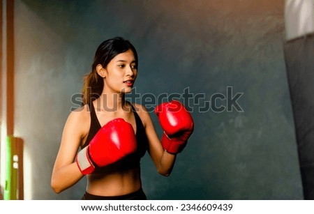 Sports boxing. Boxing. Asian woman wearing red gloves exercising with self-defense combat training. Training boxing. Muay Thai. Strike martial arts. Royalty-Free Stock Photo #2346609439